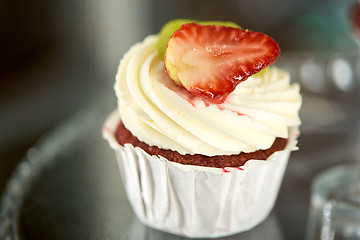 Image showing close up of cupcake with cream and strawberry