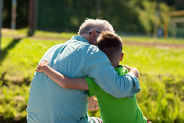 Image showing grandfather and grandson hugging outdoors