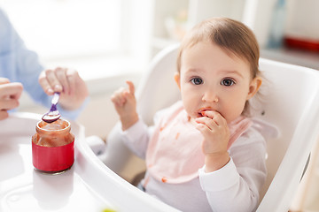 Image showing mother feeding baby with puree at home