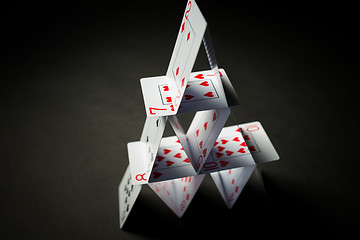 Image showing house of playing cards over black background