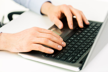 Image showing close up of male hands with laptop typing