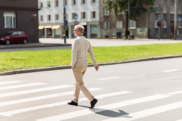 Image showing senior man walking along city crosswalk