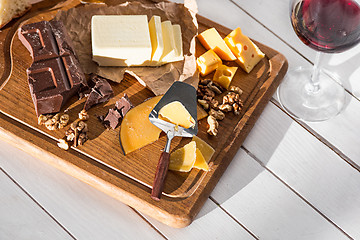 Image showing The different kind of cheese and walnuts on wooden background