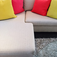 Image showing Red and yellow cushions on gray corner sofa