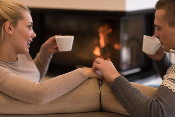 Image showing Young couple  in front of fireplace