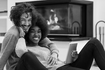 Image showing multiethnic couple used tablet computer on the floor