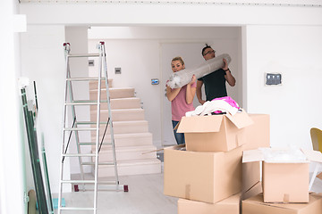 Image showing couple carrying a carpet moving in to new home