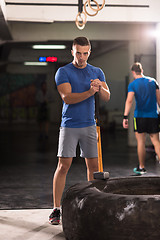 Image showing man workout with hammer and tractor tire