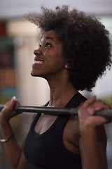 Image showing black woman lifting empty bar