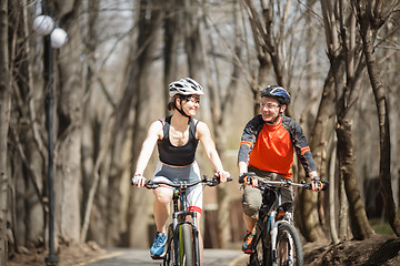 Image showing Two bicyclists drive around park