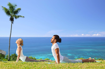 Image showing couple making yoga cobra pose outdoors