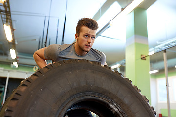 Image showing man doing strongman tire flip training in gym