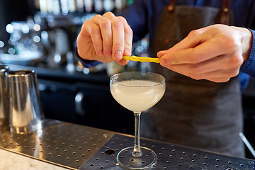 Image showing bartender with glass of cocktail and lemon at bar