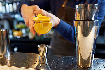 Image showing bartender squeezing juice into jigger at bar