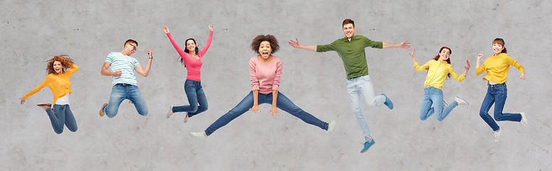 Image showing happy people or friends jumping in air over gray