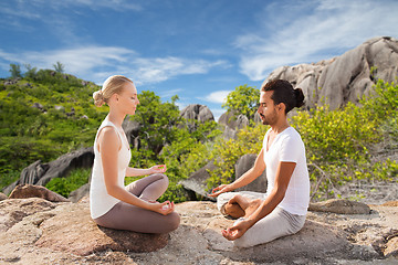 Image showing happy couple doing yoga and meditating outdoors