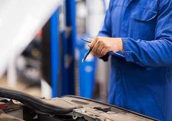 Image showing auto mechanic man with clipboard at car workshop