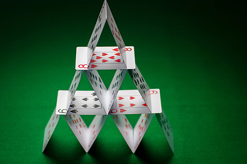 Image showing house of playing cards on green table cloth