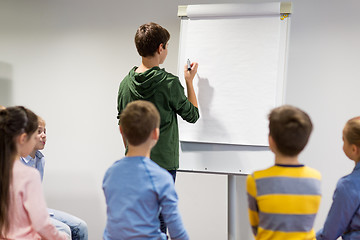 Image showing student boy with marker writing on flip board