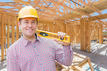 Image showing Contractor With Level On Site Inside New Home Construction Frami