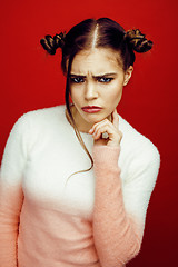 Image showing young pretty emitonal posing teenage girl on bright red background, happy smiling lifestyle people concept closeup