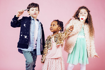 Image showing lifestyle people concept: diverse nation children playing together, caucasian boy with african little girl holding candy happy smiling closeup