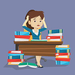 Image showing Student sitting at the table with piles of books.