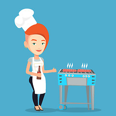 Image showing Woman cooking steak on barbecue grill.