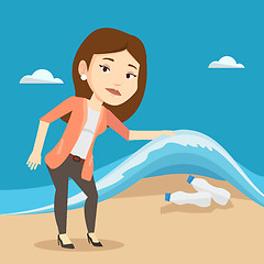 Image showing Woman showing plastic bottles under sea wave.