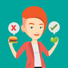 Image showing Woman choosing between hamburger and cupcake.