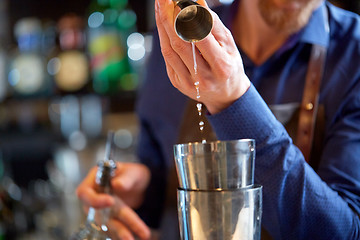 Image showing bartender with shaker preparing cocktail at bar