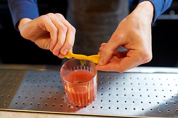 Image showing bartender with glass of cocktail and orange peel