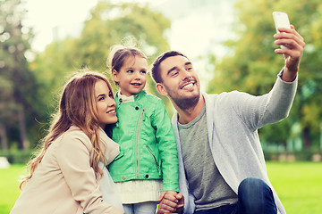 Image showing happy family taking selfie by smartphone outdoors