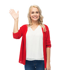 Image showing happy smiling young woman waving hand over white