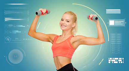 Image showing happy young sporty woman exercising with dumbbells