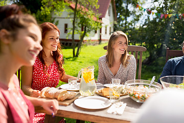 Image showing happy friends having dinner at summer garden party