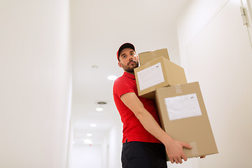 Image showing delivery man with parcel boxes in corridor