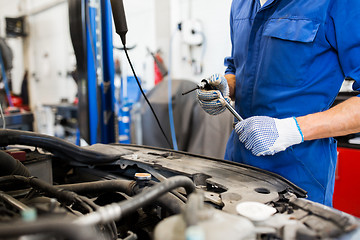 Image showing mechanic man with wrench repairing car at workshop