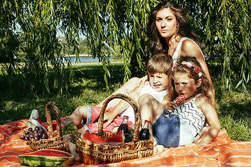 Image showing cute happy family on picnic laying on green grass mother and kid