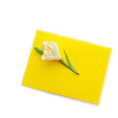 Image showing Close up of yellow envelope with flower