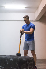 Image showing man workout with hammer and tractor tire