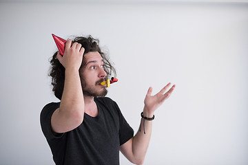 Image showing Portrait of a man in party hat blowing in whistle