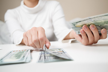 Image showing Close up of woman with calculator counting money