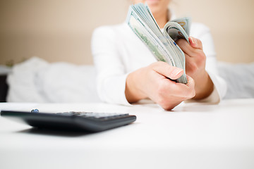 Image showing business, finance, saving, banking and people concept - close up of woman hands counting us dollar money