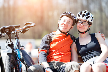 Image showing Photo of bicyclists on bench