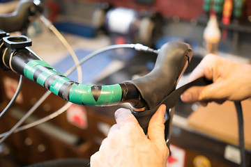 Image showing Man repairing helm of bicycle