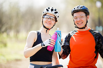 Image showing Cyclists with water in hands