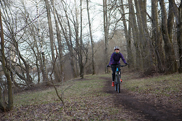 Image showing Woman in helmet riding bicycle