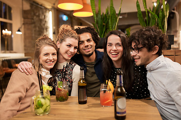 Image showing happy friends with drinks at bar or cafe