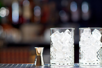 Image showing glasses with ice and jigger on bar counter